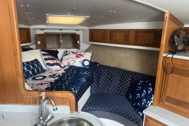 Slide: The Image of Cozy cabin interior of a 1995 Cabo 35 Express boat with nautical-themed bedding. - 11