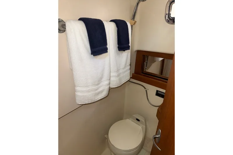 Slide: The Image of 2002 Mainship Pilot 34 bathroom with towels, mirror, and toilet. - 13