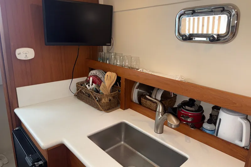 Slide: The Image of Compact kitchen area in a 2002 Mainship Pilot 34 boat with sink and appliances. - 12