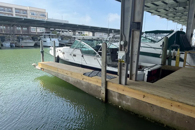 Slide: The Image of 2002 Mainship Pilot 34 docked in a marina under a covered structure. - 2