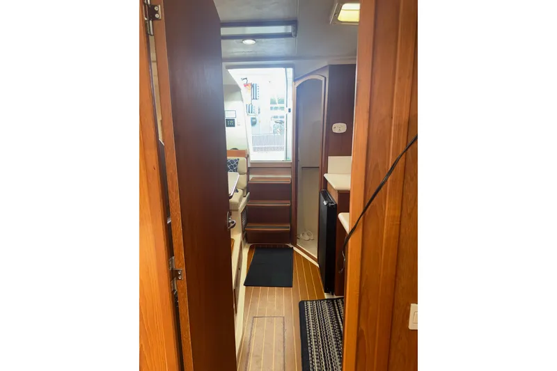 Slide: The Image of Interior view of 2002 Mainship Pilot 34 boat, featuring wooden cabinetry and compact layout. - 10