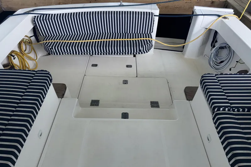 Slide: The Image of 2002 Mainship Pilot 34 boat interior with striped seating and deck storage. - 18