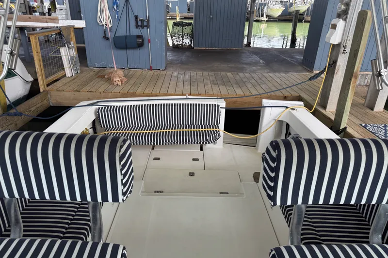 Slide: The Image of 2002 Mainship Pilot 34 boat interior with striped seating at a dock. - 24