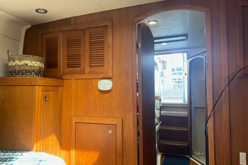 Slide: The Image of Interior of 2002 Mainship Pilot 34 boat with wooden cabinetry and open door. - 9
