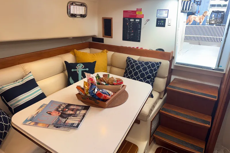 Slide: The Image of Cozy interior of 2002 Mainship Pilot 34 with dining area and nautical decor. - 16