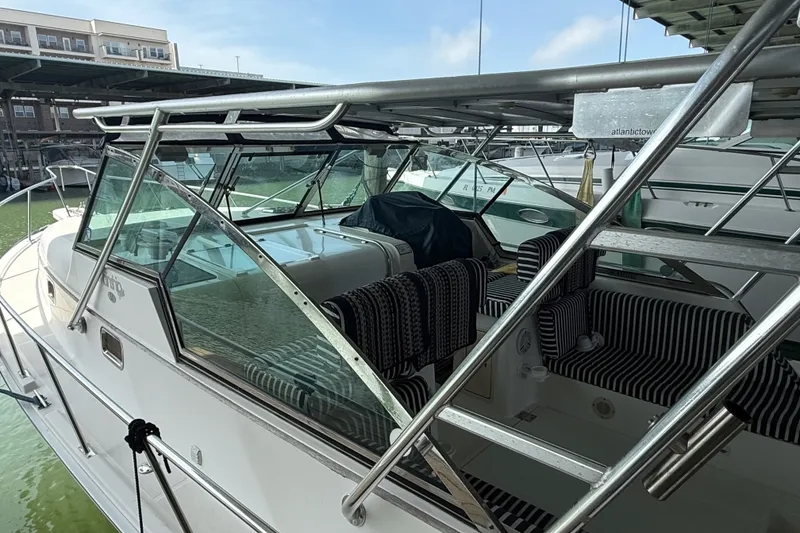 Slide: The Image of 2002 Mainship Pilot 34 boat with striped seating, docked in a marina. - 6
