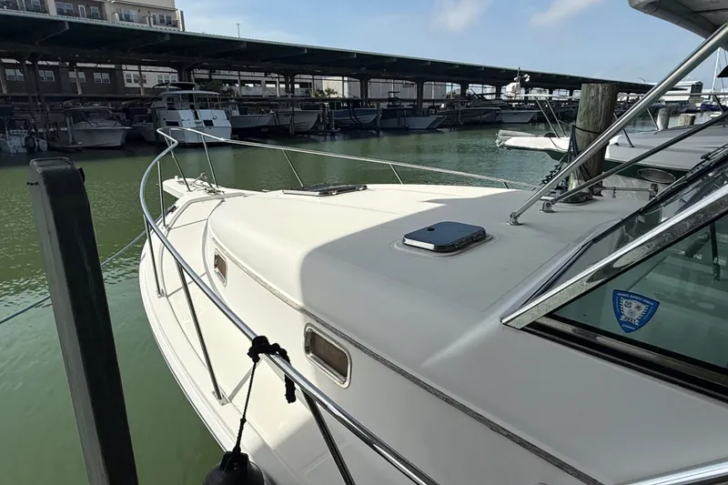 Slide: The Image of 2002 Mainship Pilot 34 docked at marina, showcasing sleek design and spacious deck. - 7