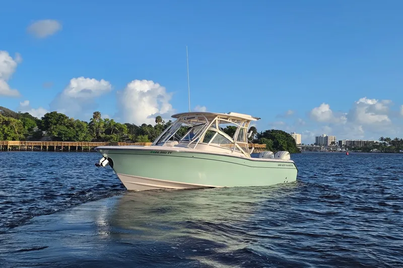 Slide: The Image of 2024 Grady-White Freedom 275 boat cruising on a sunny day with scenic background. - 21