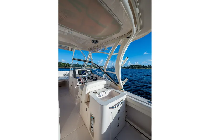 Slide: The Image of 2024 Grady-White Freedom 275 boat interior with steering wheel, overlooking blue water. - 13