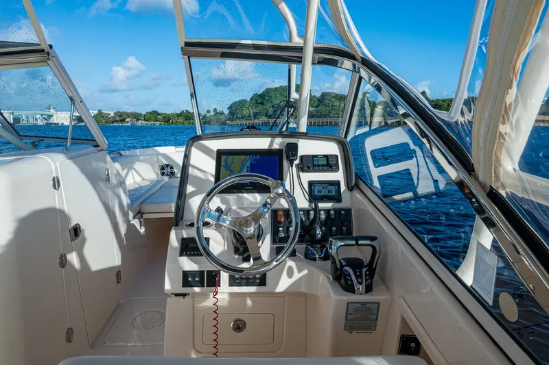 Slide: The Image of 2024 Grady-White Freedom 275 boat cockpit with steering wheel and navigation system. - 6
