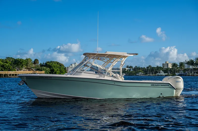 Slide: The Image of 2024 Grady-White Freedom 275 boat on water, clear blue sky background. - 3