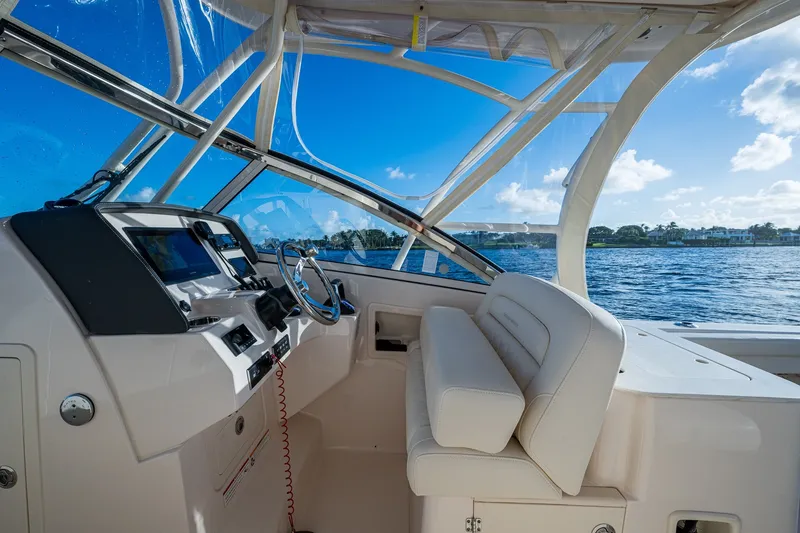 Slide: The Image of 2024 Grady-White Freedom 275 boat interior with helm and seating, overlooking water. - 8