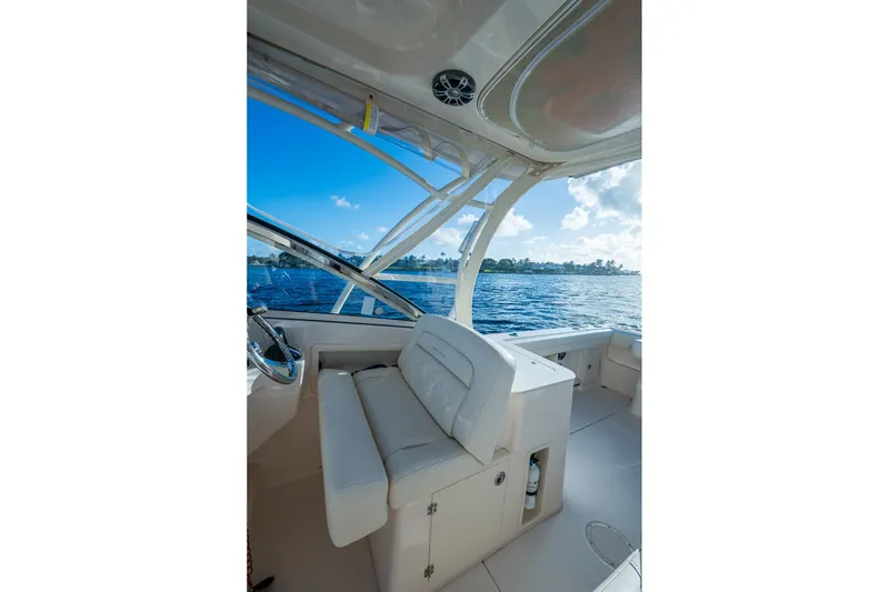 Slide: The Image of 2024 Grady-White Freedom 275 boat interior with seating, overlooking serene waters. - 7