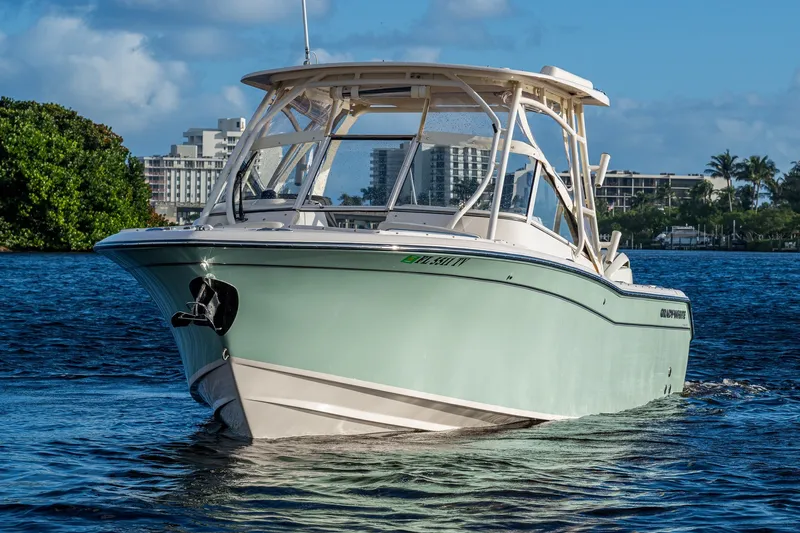 Slide: The Image of 2024 Grady-White Freedom 275 boat on water, cityscape background, sunny day. - 2