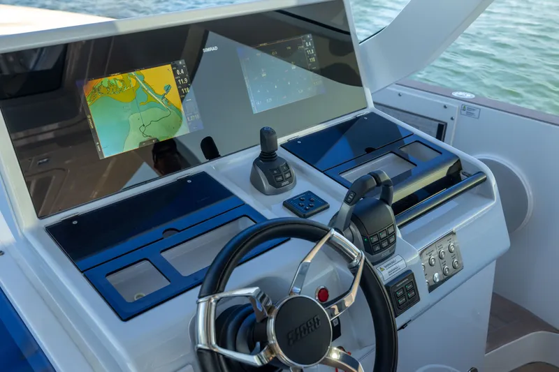 Slide: The Image of Control panel of 2023 Fjord 41 XL yacht with navigation screens and steering wheel. - 36