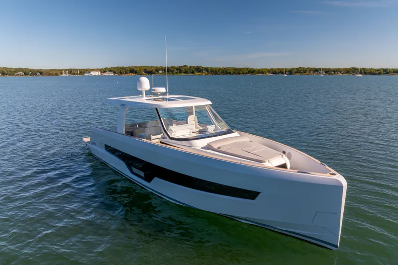 Slide: The Image of 2023 Fjord 41 XL yacht cruising on a serene lake under a clear blue sky. - 8