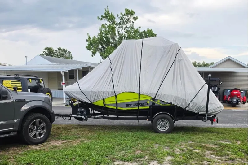 Slide: The Image of Covered 2017 Scarab 195 ID boat on trailer, parked near residential area. - 17
