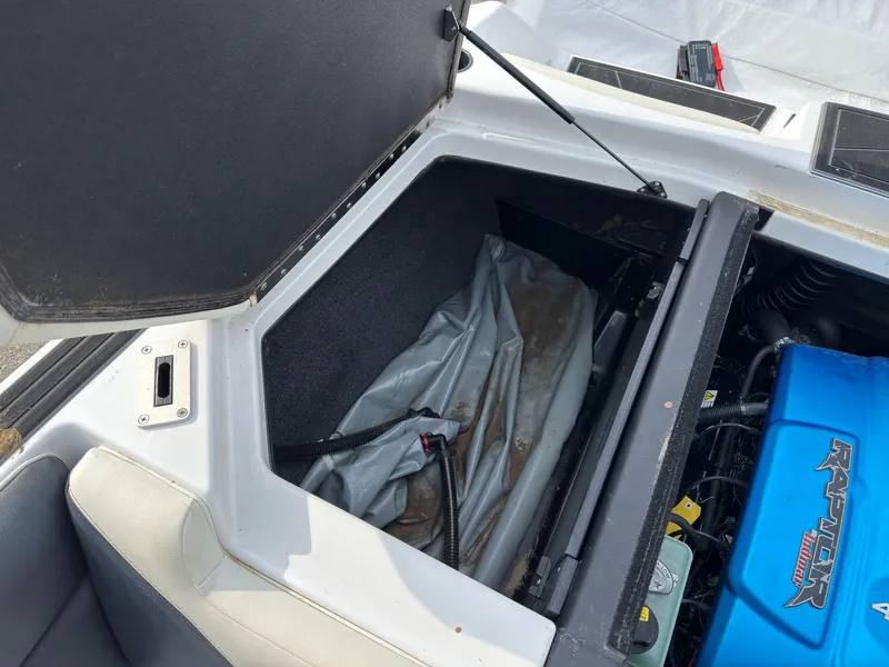 Slide: The Image of An open storage compartment in a boat's rear with a blue engine block. - 12
