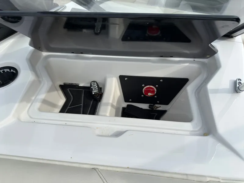 Slide: The Image of An open storage compartment on a 2020 ATX Surf Boat 22 Type-S with a red switch. - 24