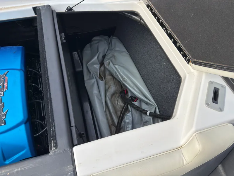 Slide: The Image of A boat storage compartment with a blue battery and a gray cover. - 14