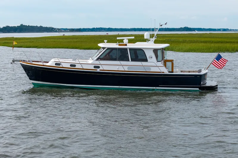 Slide: The Image of 2009 Grand Banks 45 Eastbay SX yacht cruising on calm waters with American flag. - 98