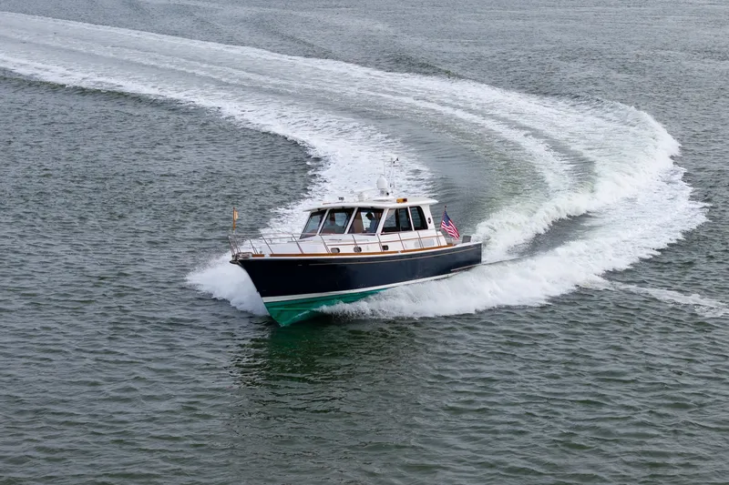 Slide: The Image of 2009 Grand Banks 45 Eastbay SX cruising on open water, creating a dynamic wake. - 14