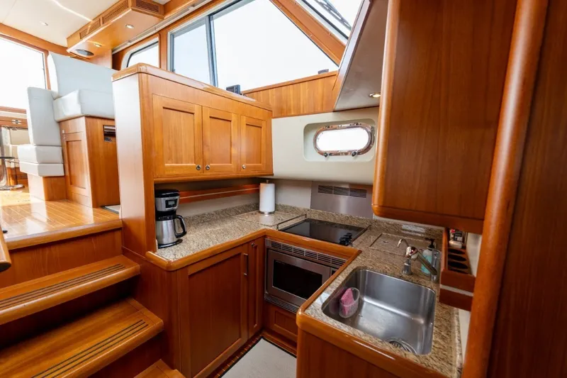 Slide: The Image of Luxurious 2009 Grand Banks 45 Eastbay SX yacht kitchen with wood cabinetry and modern appliances. - 58