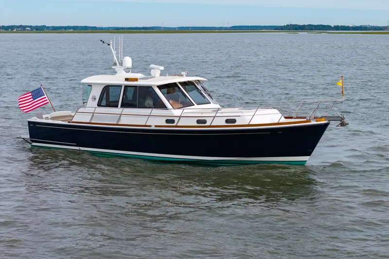 Slide: The Image of 2009 Grand Banks 45 Eastbay SX yacht cruising on open water with American flag. - 95