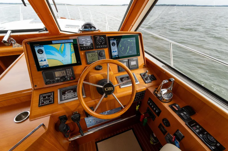 Slide: The Image of Helm of 2009 Grand Banks 45 Eastbay SX with navigation screens and wooden steering wheel. - 31