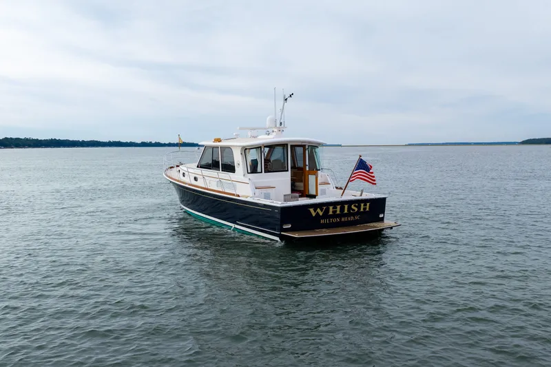 Slide: The Image of 2009 Grand Banks 45 Eastbay SX yacht on calm waters, rear view with American flag. - 89