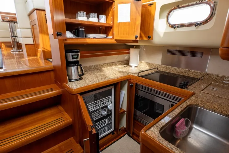 Slide: The Image of Luxurious 2009 Grand Banks 45 Eastbay SX yacht kitchen with wood cabinetry and modern appliances. - 51