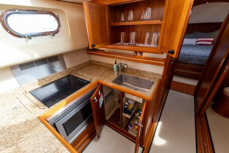 Slide: The Image of Luxurious 2009 Grand Banks 45 Eastbay SX yacht kitchen with granite countertops and wooden cabinetry. - 57