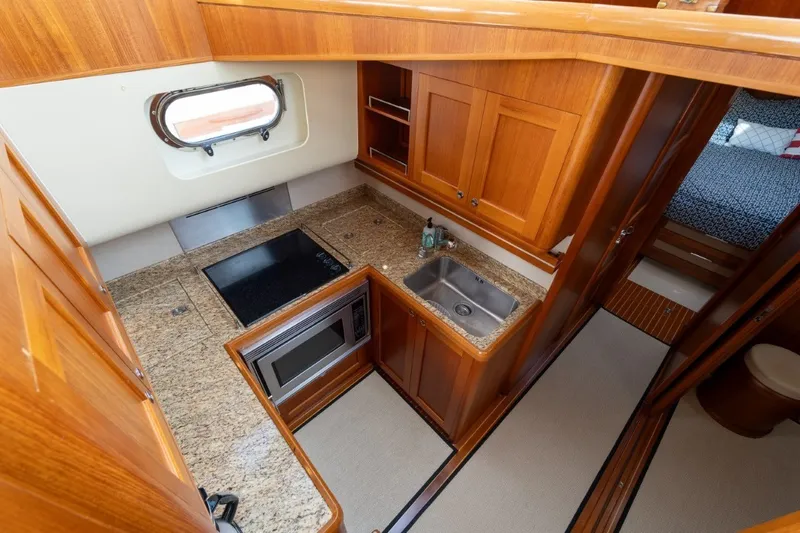 Slide: The Image of Luxurious 2009 Grand Banks 45 Eastbay SX yacht kitchen with granite countertops and wooden cabinetry. - 50