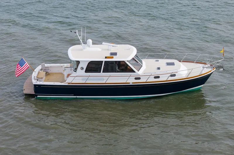 Slide: The Image of 2009 Grand Banks 45 Eastbay SX yacht on calm water, displaying American flag. - 96
