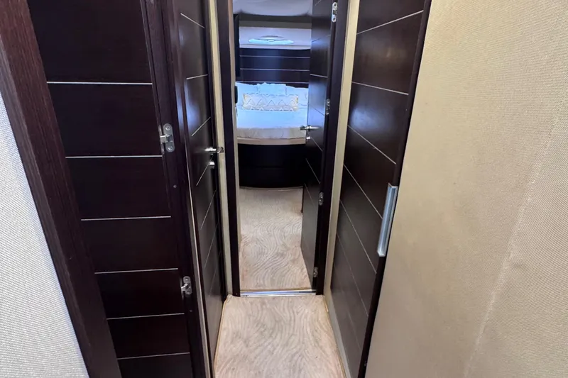 Slide: The Image of Interior hallway of 2006 Azimut 68S yacht, featuring dark wood doors and beige walls. - 46