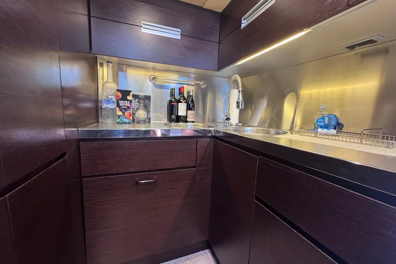 Slide: The Image of Luxurious kitchen area in a 2006 Azimut 68S yacht with modern fixtures and dark wood cabinetry. - 42