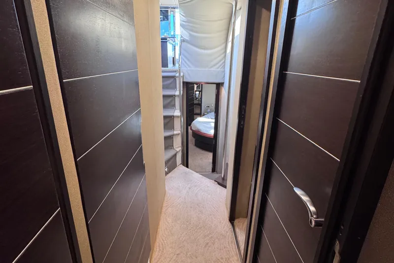 Slide: The Image of Hallway inside 2006 Azimut 68S yacht, featuring modern dark wood paneling. - 64