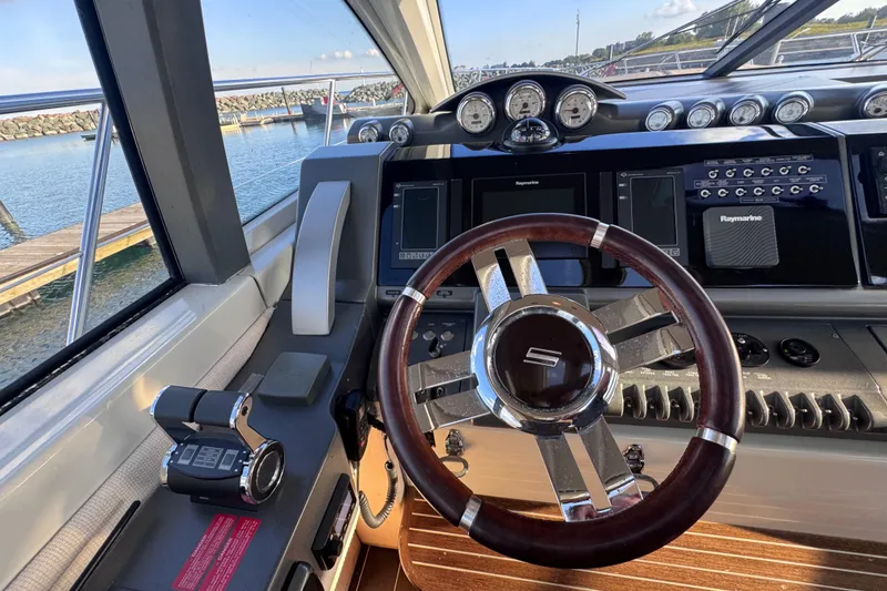 Slide: The Image of Steering wheel and dashboard of a 2006 Azimut 68S yacht, featuring modern navigation equipment. - 25