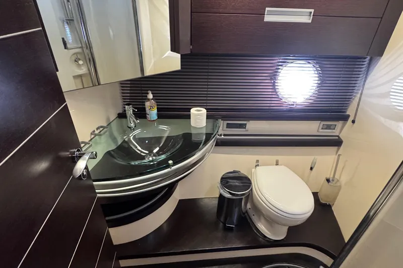Slide: The Image of Luxurious bathroom in a 2006 Azimut 68S yacht with modern fixtures and porthole window. - 57
