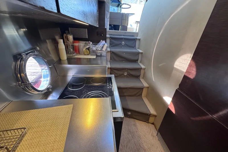 Slide: The Image of 2006 Azimut 68S yacht kitchen with stove, porthole, and stairs. - 44