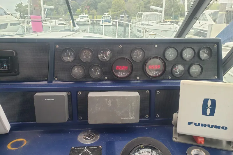 Slide: The Image of Dashboard of a 1988 Sea Ray 390 Express Cruiser with gauges and navigation equipment. - 15