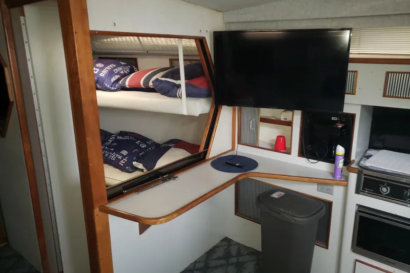 Slide: The Image of Interior of 1988 Sea Ray 390 Express Cruiser with bunk beds and TV. - 5