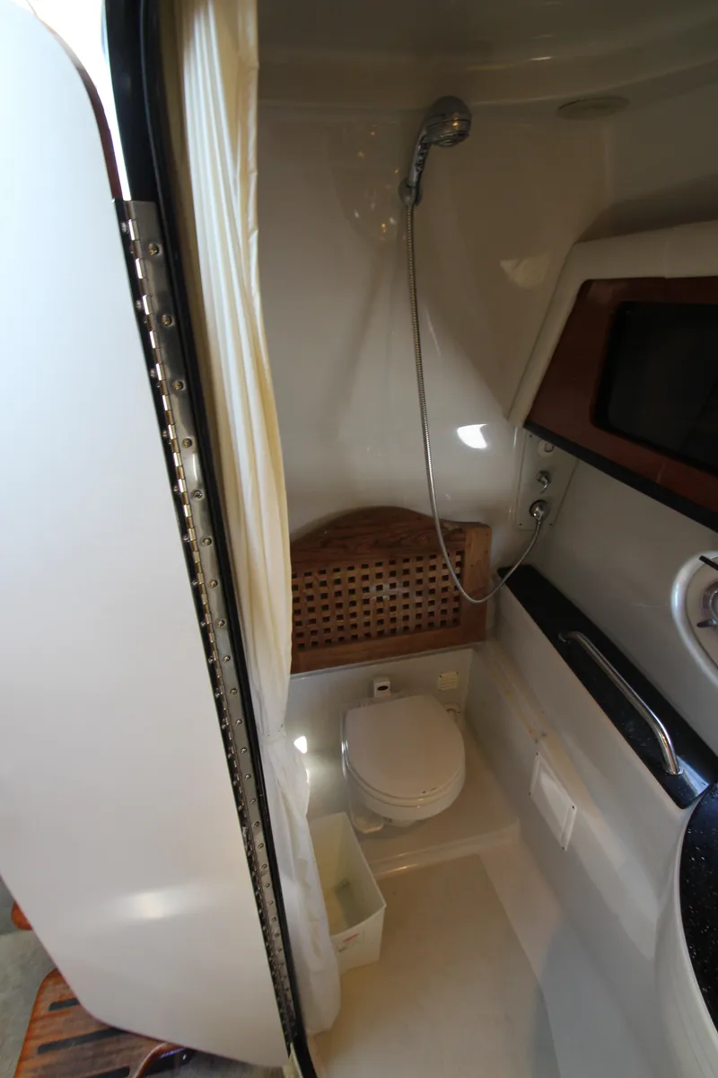 Slide: The Image of 2008 Crownline 340 CR boat bathroom with shower, toilet, and wooden seat. - 40