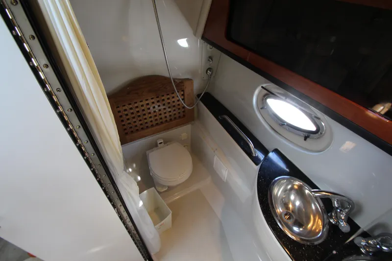 Slide: The Image of 2008 Crownline 340 CR yacht bathroom with toilet, sink, and shower. - 32