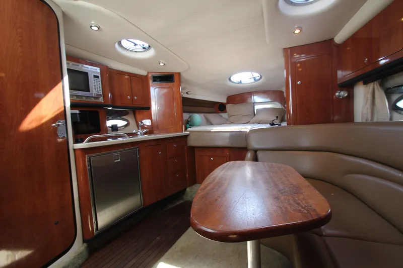 Slide: The Image of 2008 Crownline 340 CR yacht interior with wood cabinetry, kitchenette, and seating area. - 34