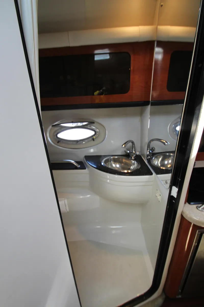 Slide: The Image of 2008 Crownline 340 CR yacht bathroom with modern sink and porthole window. - 41