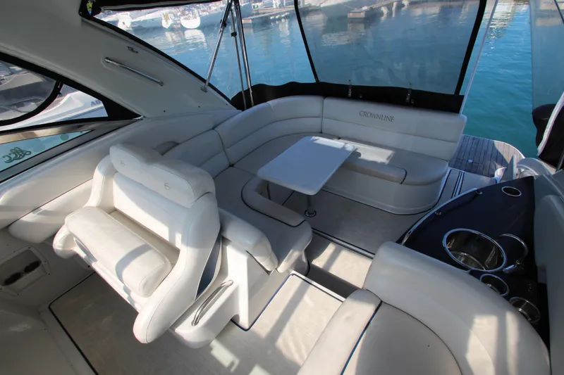 Slide: The Image of 2008 Crownline 340 CR yacht interior with white seating and table, docked at marina. - 19
