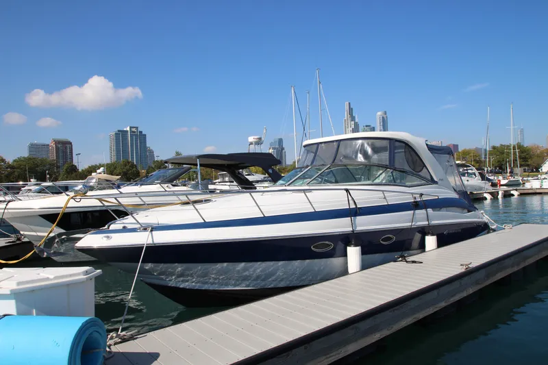 Slide: The Image of 2008 Crownline 340 CR yacht docked at marina with city skyline in background. - 1