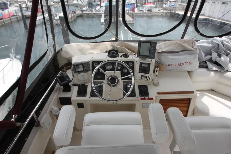 Slide: The Image of 1990 Silverton 34 Convertible yacht cockpit with steering wheel and navigation equipment. - 42