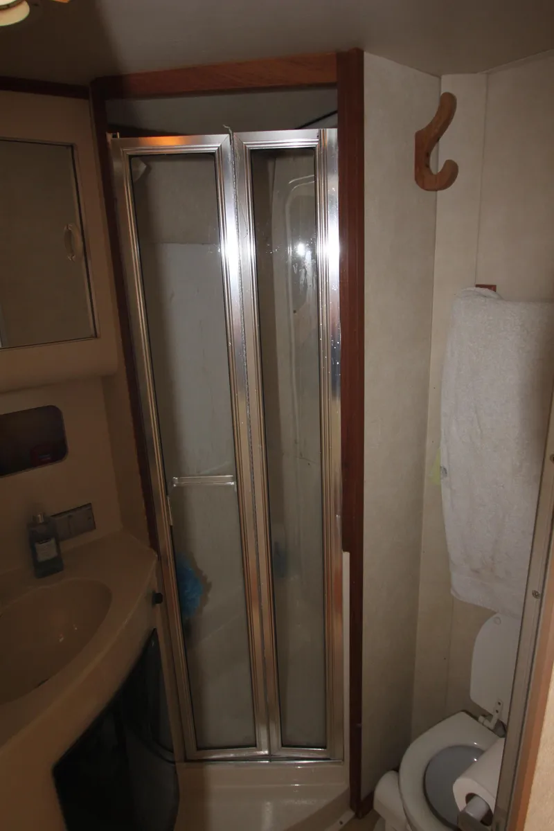 Slide: The Image of 1990 Silverton 34 Convertible bathroom with shower, sink, and toilet. - 26